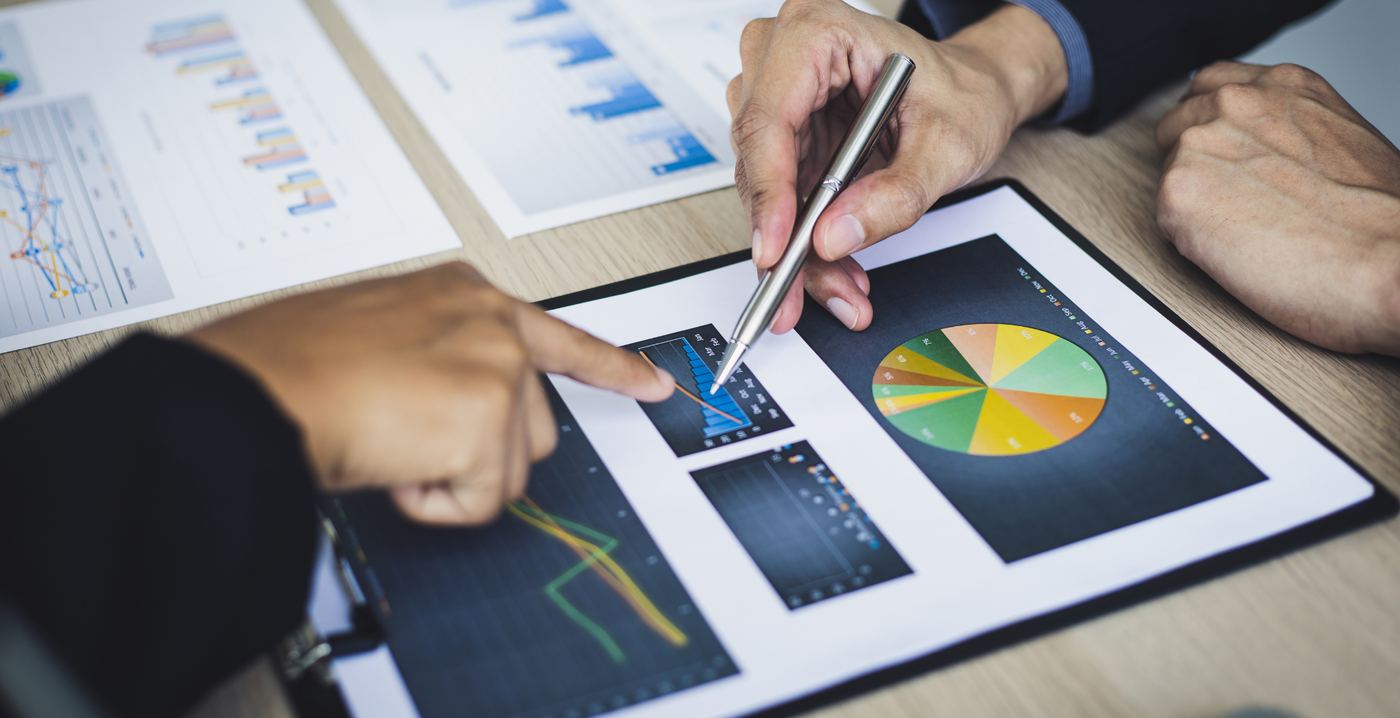 Consultores analisando relatórios e gráficos impressos sobre a mesa